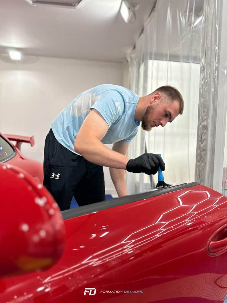 Homme polissant voiture rouge