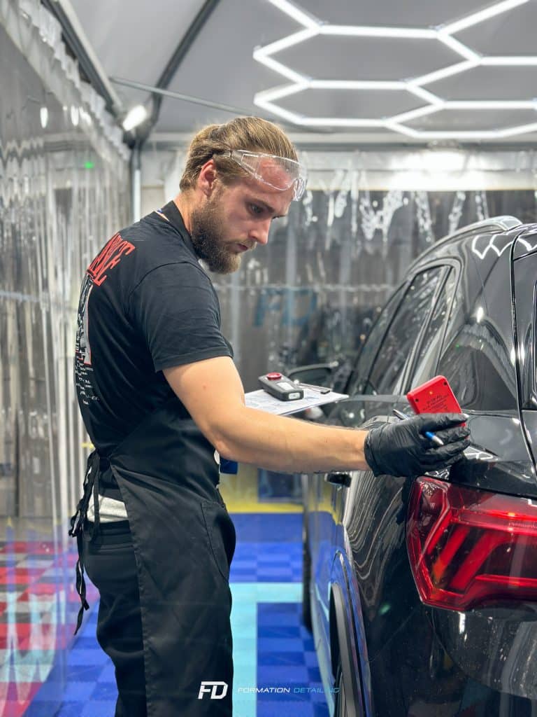 Homme nettoyant méticuleusement une voiture noire