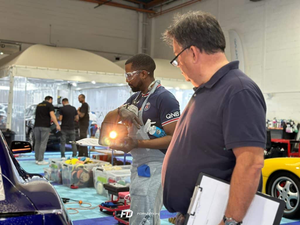 Deux hommes inspectant une voiture dans un atelier