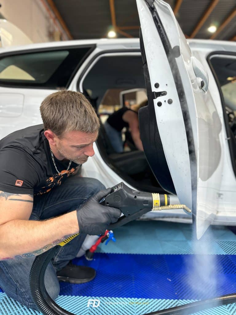Homme réparant porte de voiture avec outil