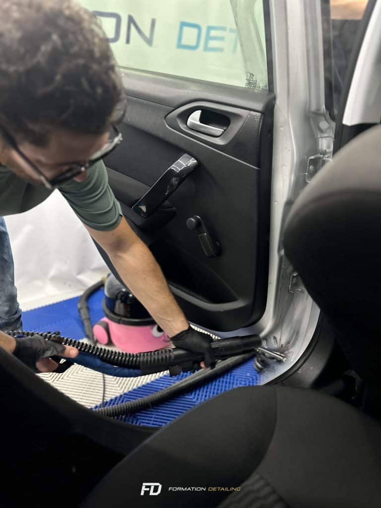 Homme nettoyant l'intérieur d'une voiture