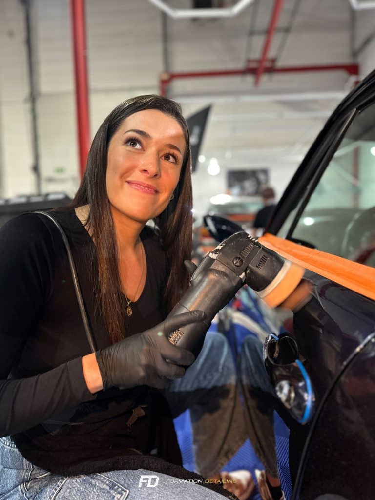 Femme souriante polissant une voiture