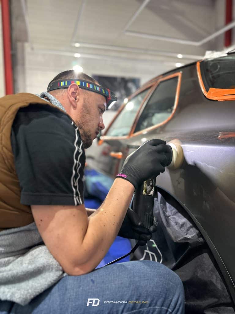 Homme polissant voiture dans garage
