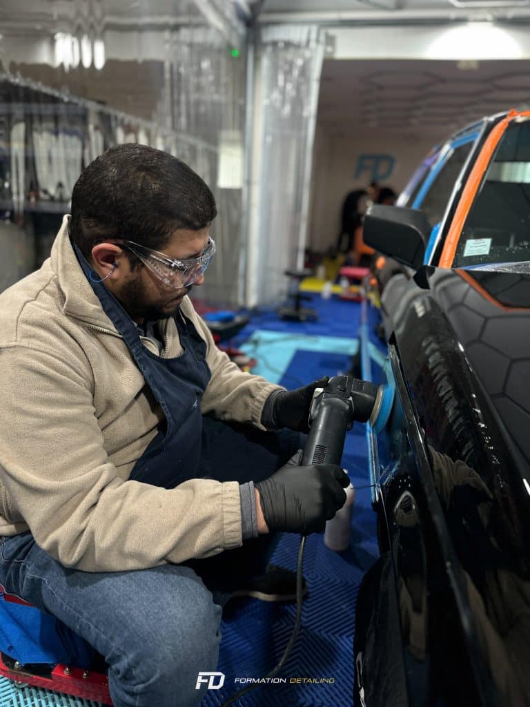 Homme polissant une voiture en atelier