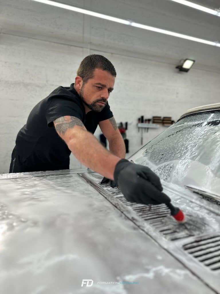 Homme nettoyant voiture avec sérieux