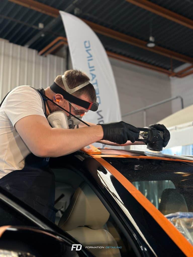 Homme polissant voiture en atelier