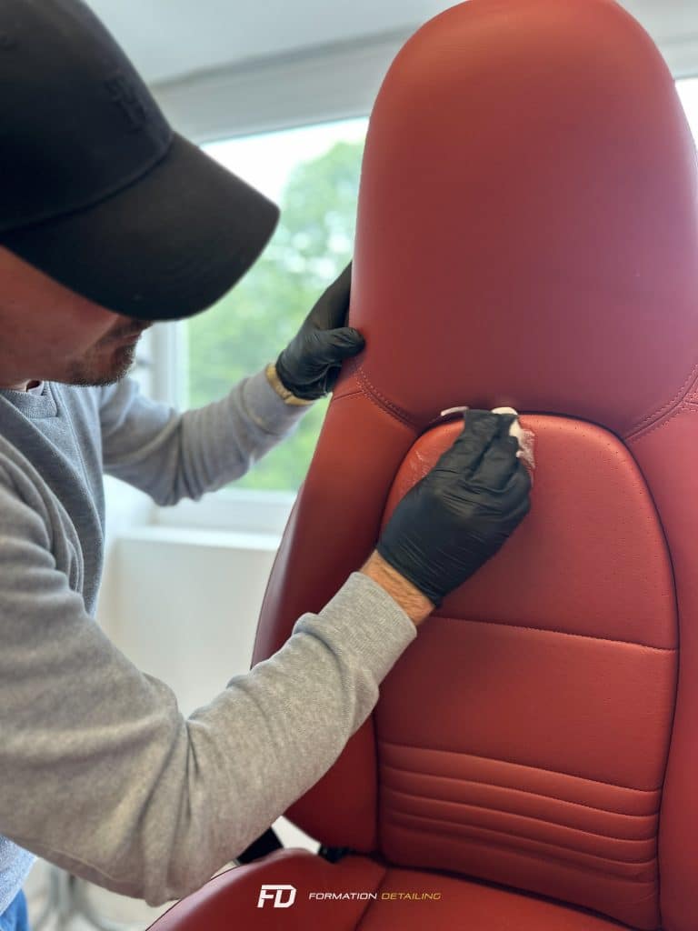 Homme rénovant un siège auto rouge