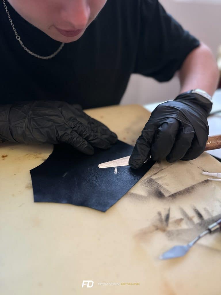Artisan gravant minutieusement un cuir noir