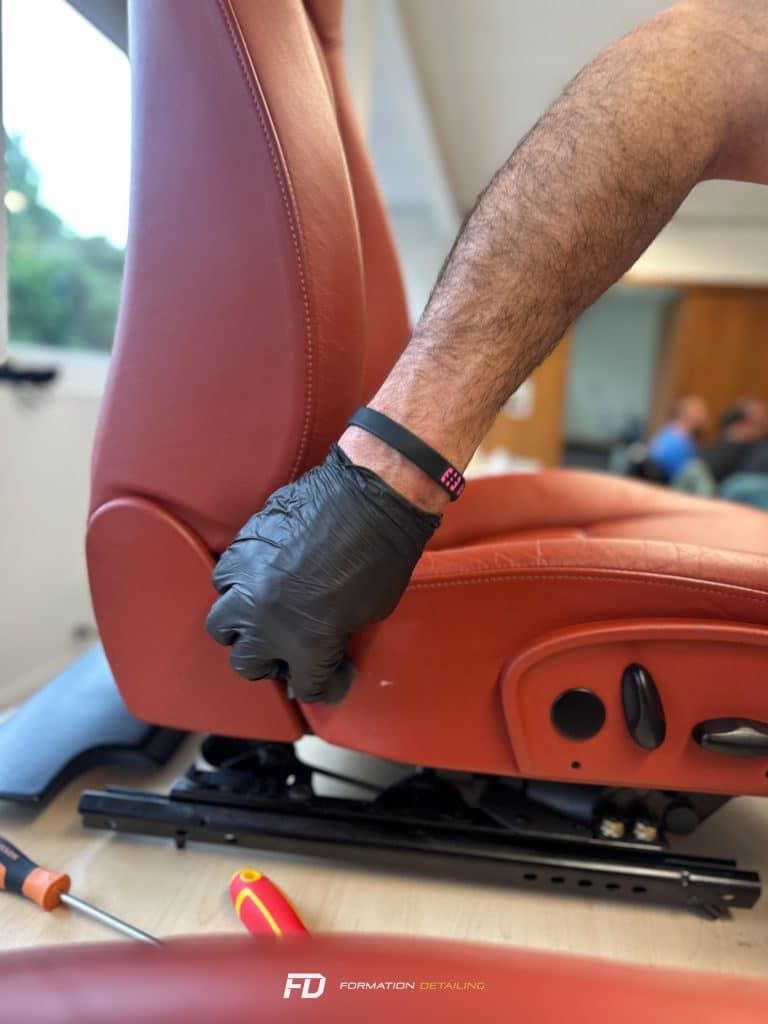 Main en gant réparant siège auto rouge